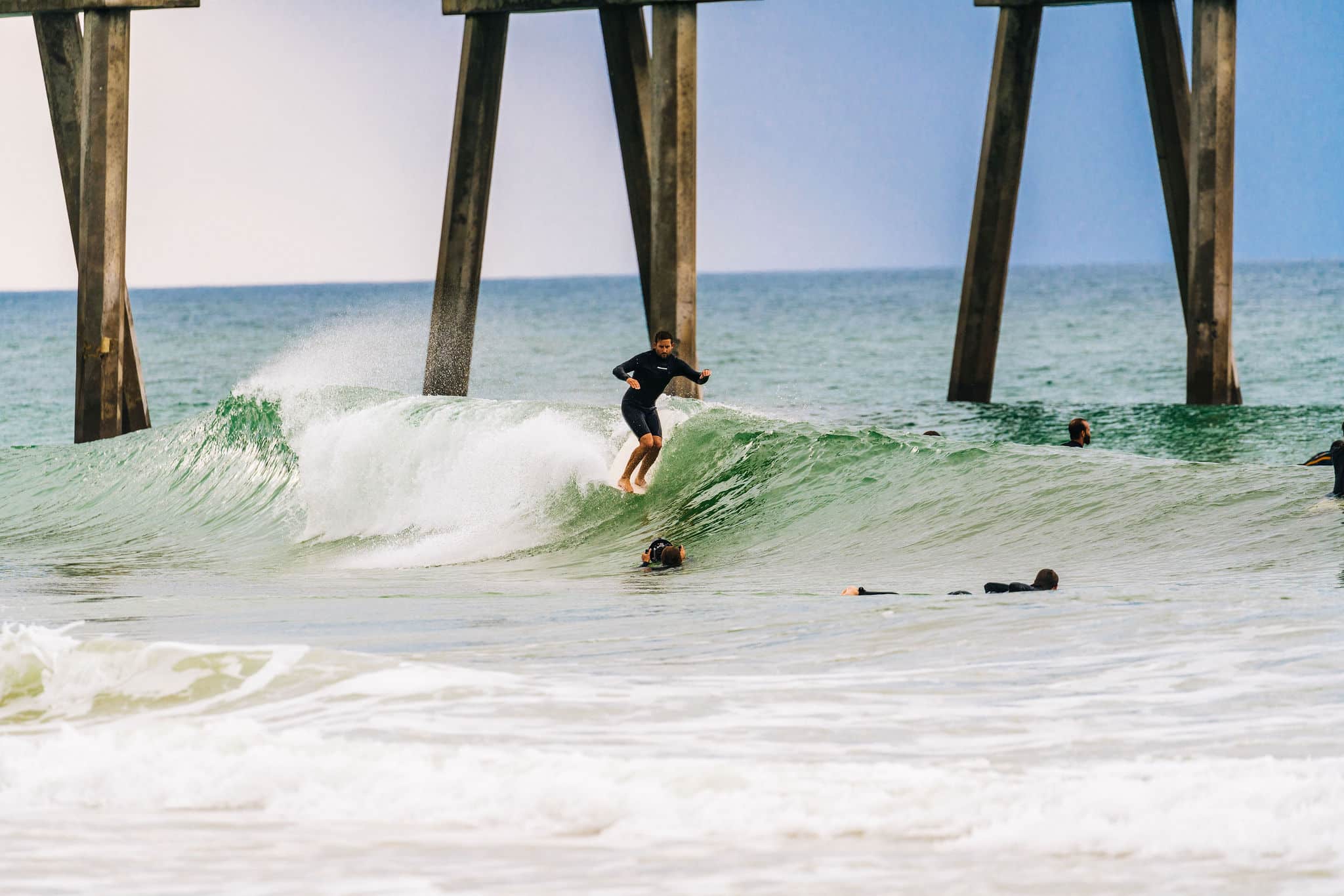 Surfers surfing in Pensacola Beach, Florida.