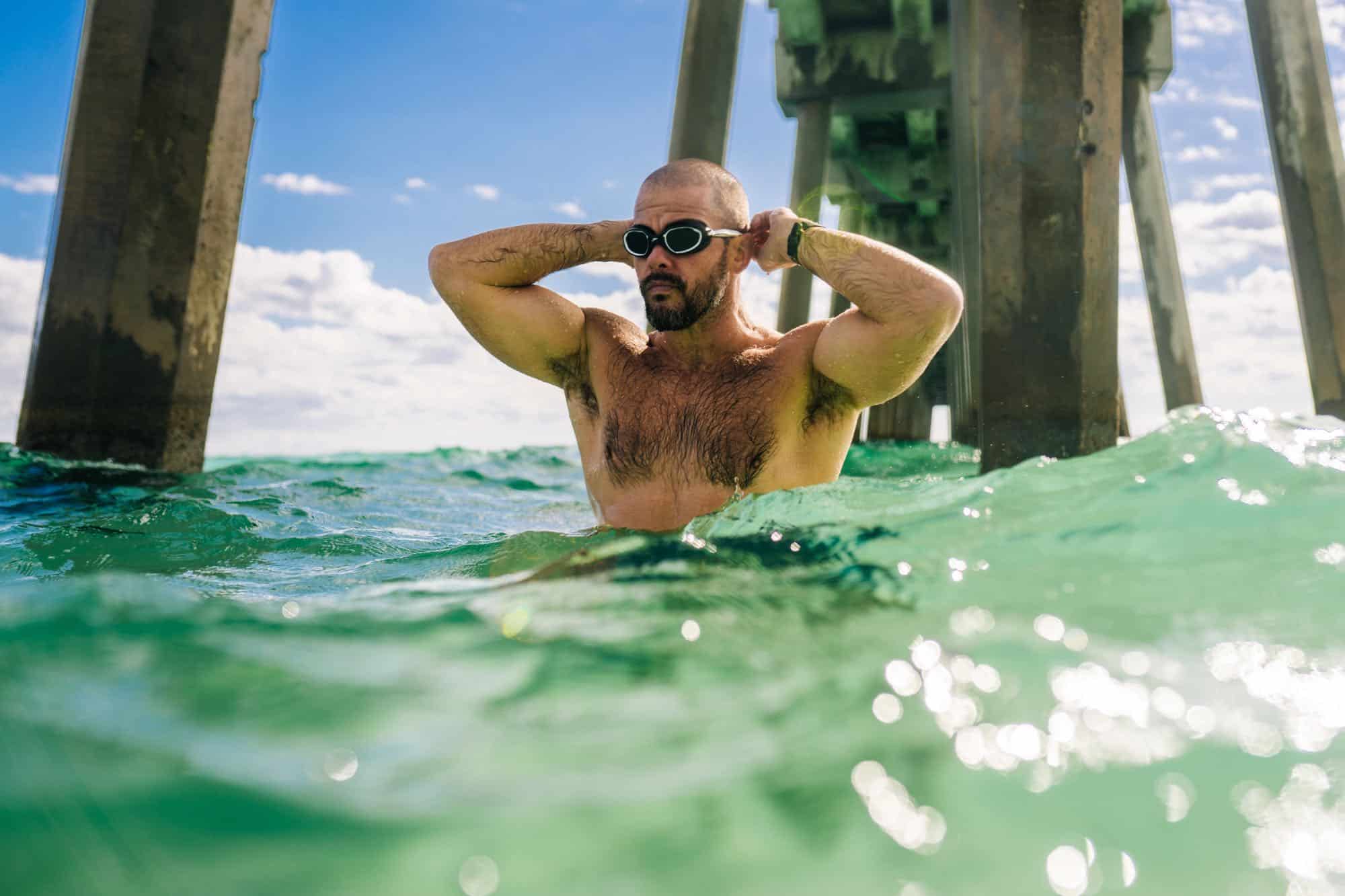 Swimmer with goggles near a pier in Pensacola Beach, Florida.