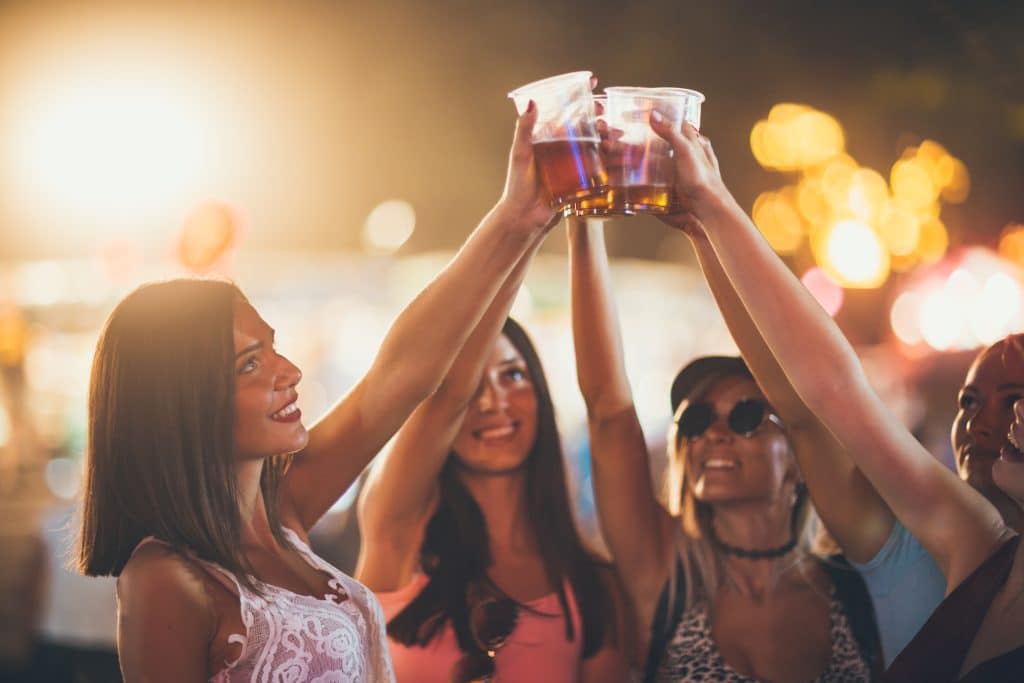 Women toasting with beer at the music festival.