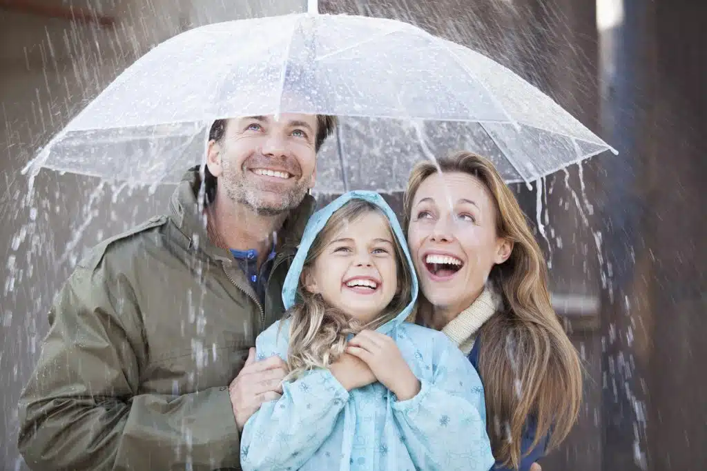 Family under an umbrella on a rainy day.